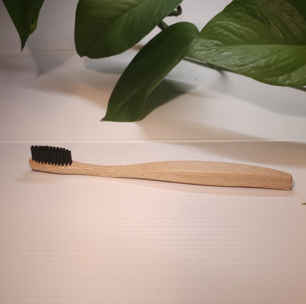 A bamboo toothbrush with a wooden handle and black bristles