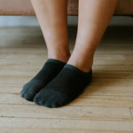 a pair of grey no show spot bamboo socks being worn