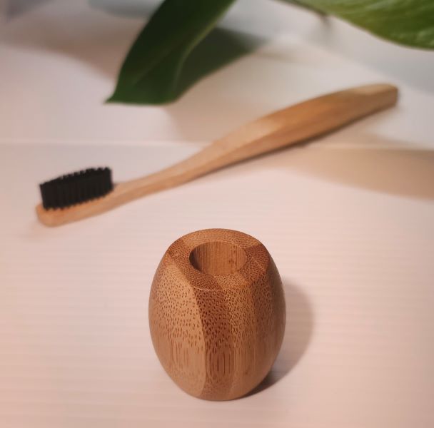 bamboo holder with toothbrush in background