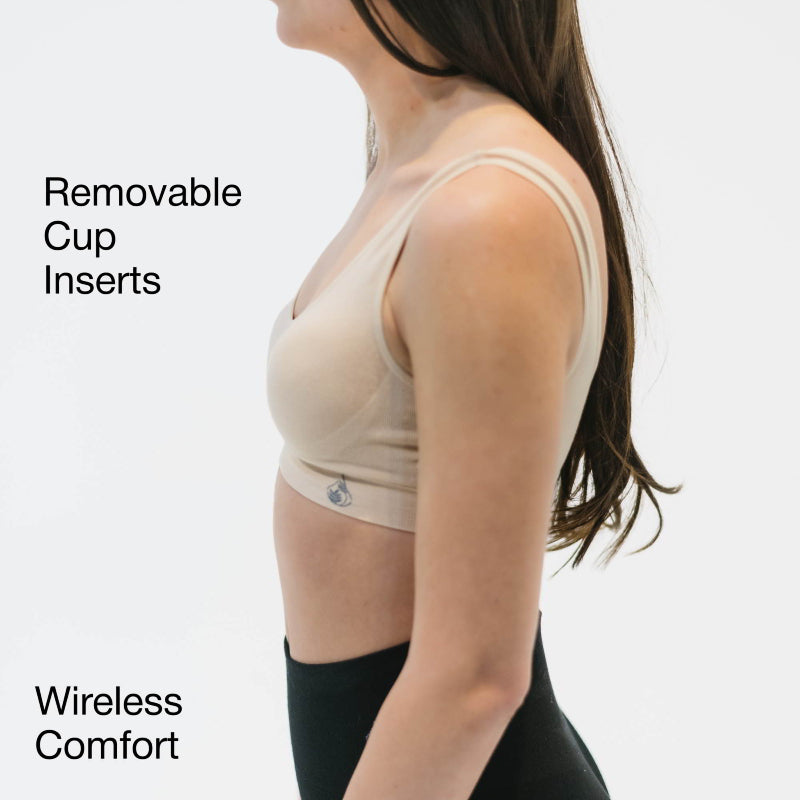 Woman wearing a beige wireless bra with removable cup inserts and wireless comfort.