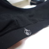 Close-up of black bra with a small caroquilla logo