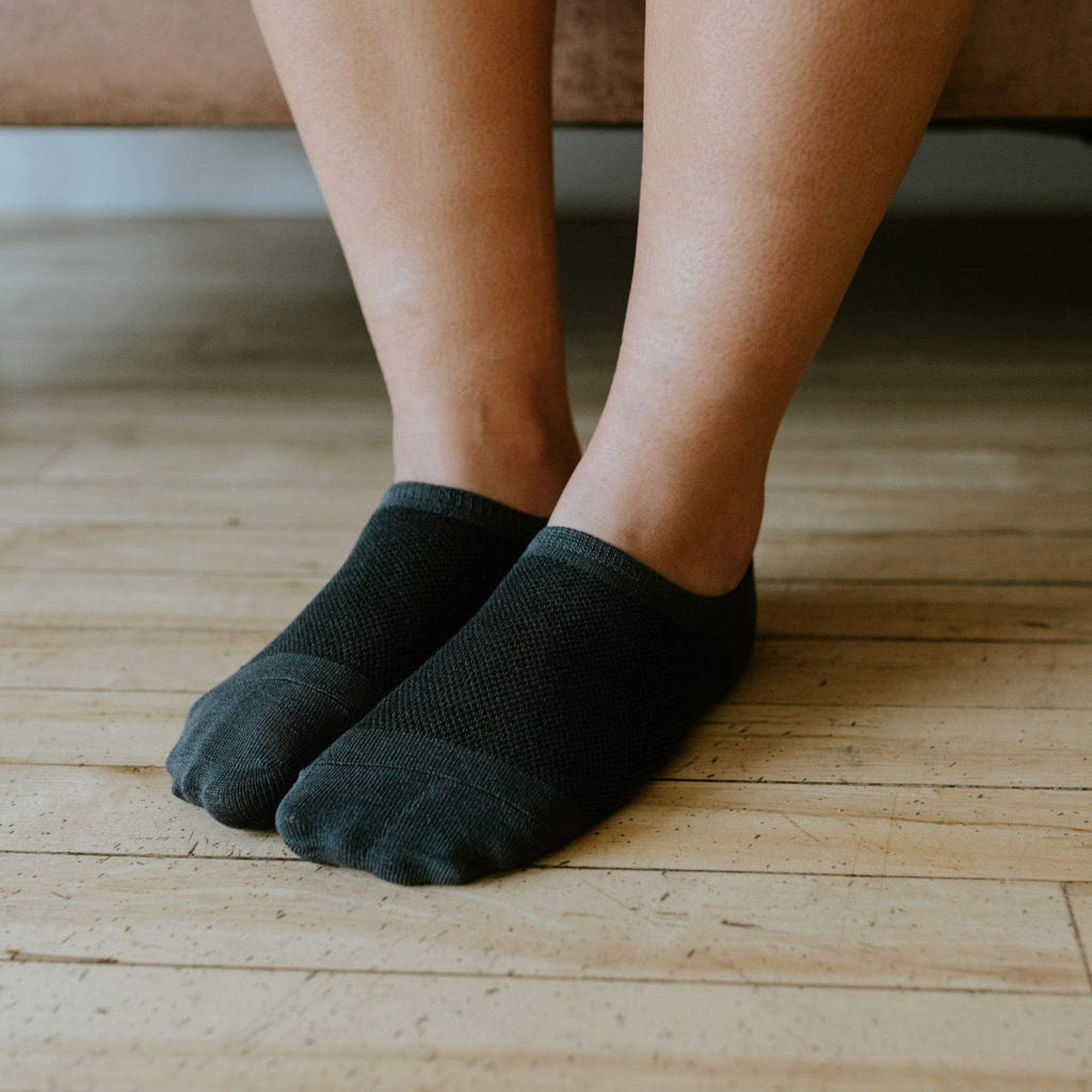 a pair of grey no show spot bamboo socks being worn 