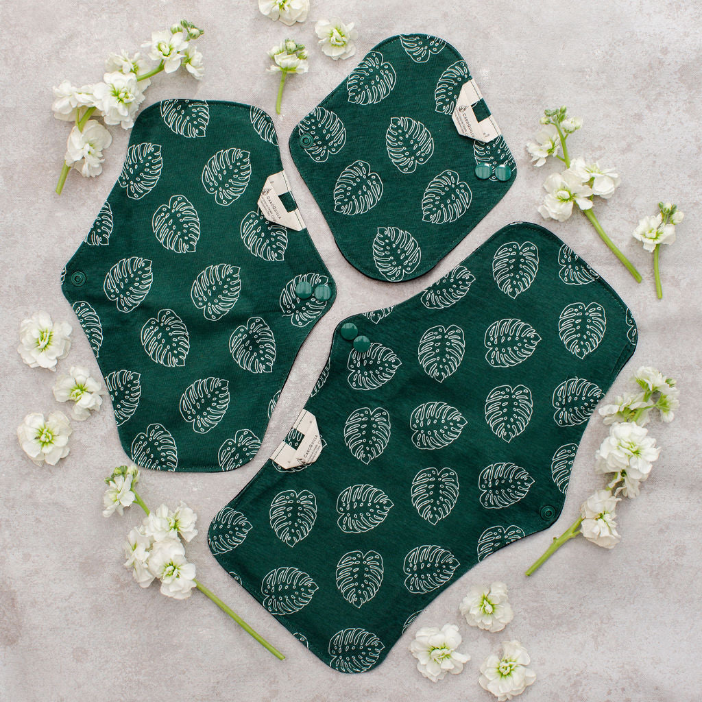 exterior of the three sizes of reusable bamboo pads with leaf pattern and flowers surrounding them