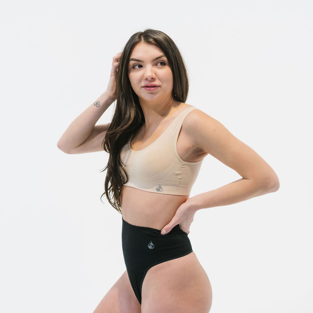 woman wearing bamboo padded bra in beige and tummy hugging bamboo thong in black 