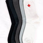 five pairs of socks in black, dark grey, gray, and white with a red maple leaf logo 