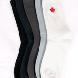 five pairs of socks in black, dark grey, gray, and white with a red maple leaf logo 