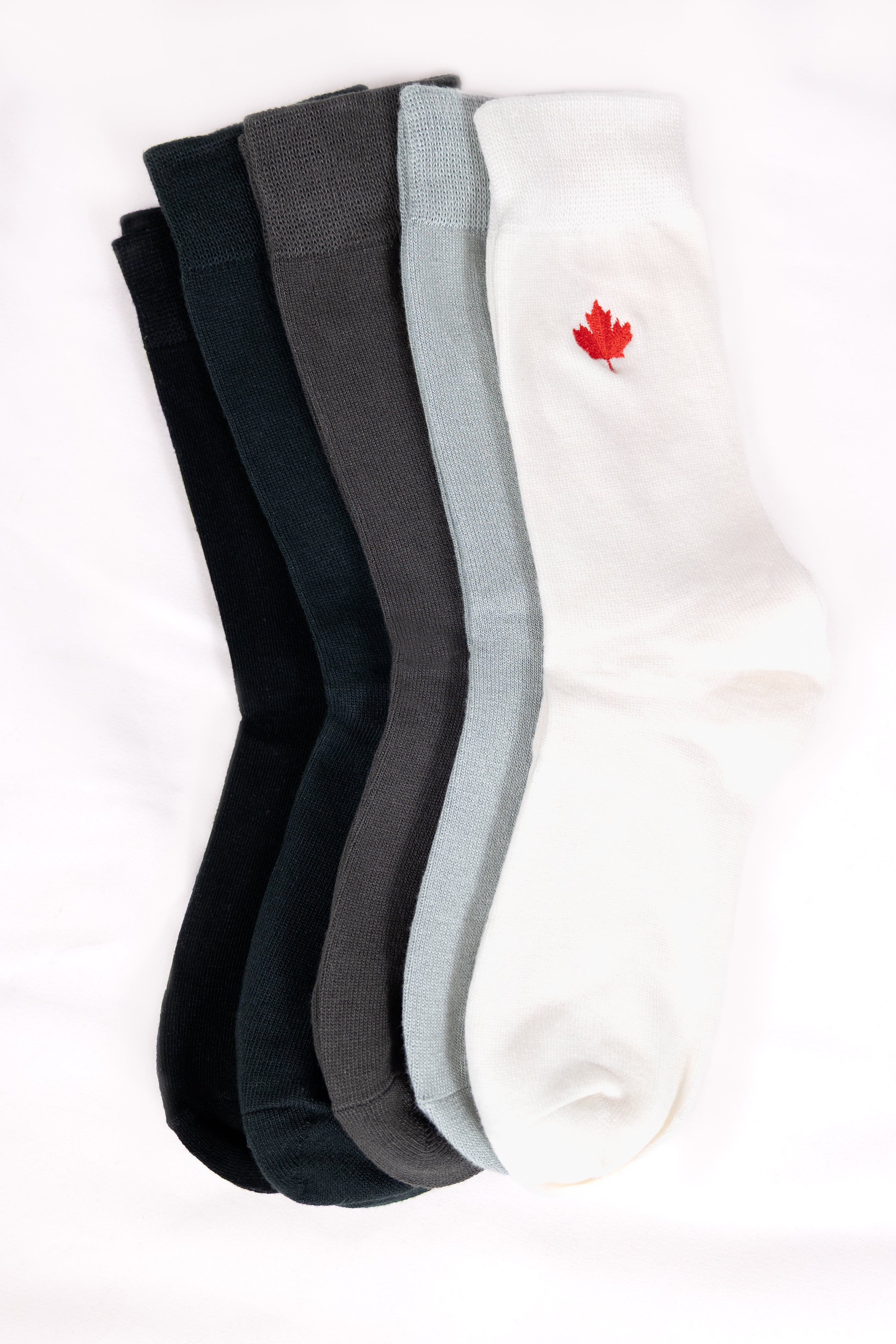 five pairs of socks in black, dark grey, gray, and white with a red maple leaf logo 